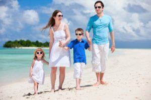13192327 - young beautiful family with two kids walking at beach